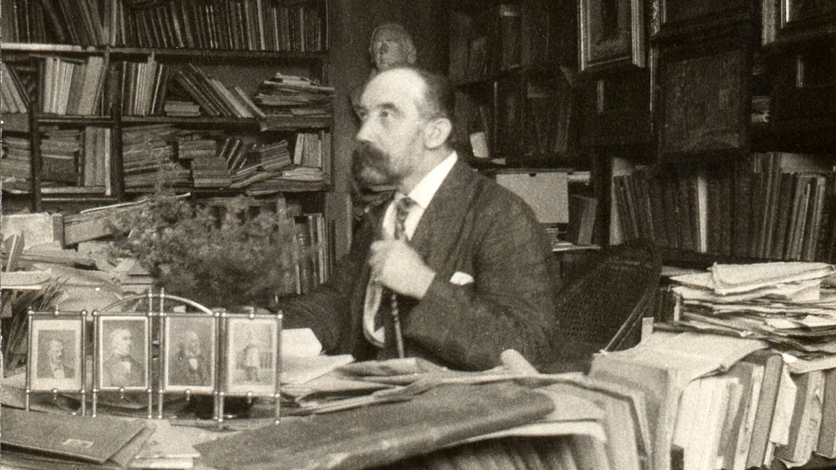 Svart-hvitt fotografi av Moltke Moe i sitt arbeidsværelse.