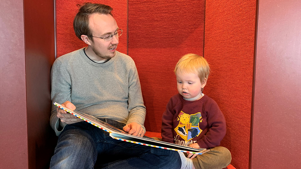 A father and son are reading a book.