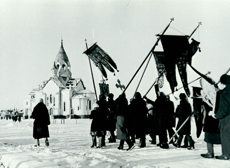 Black and white photo of procession outside a church.