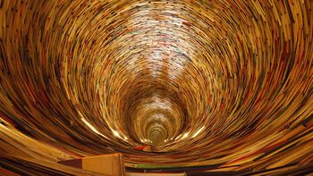 Books that are stacked in the shape as a tunnel. Photo.