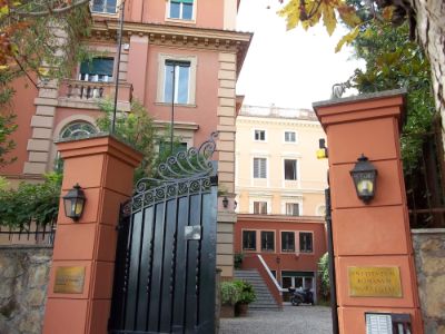 Inngangen til det norske institutt i Roma. En åpen port og bygget i bakgrunnen. Foto.