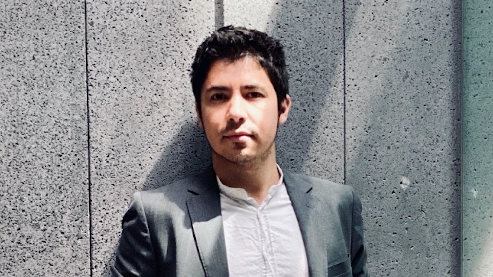 A picture of Víctor Bermúdez leaning against a wall. 