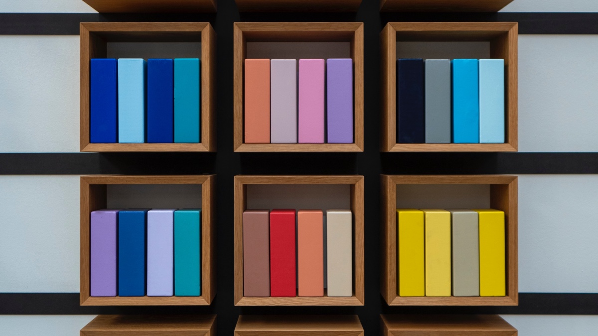 A shelf with books in different colours. Photo.