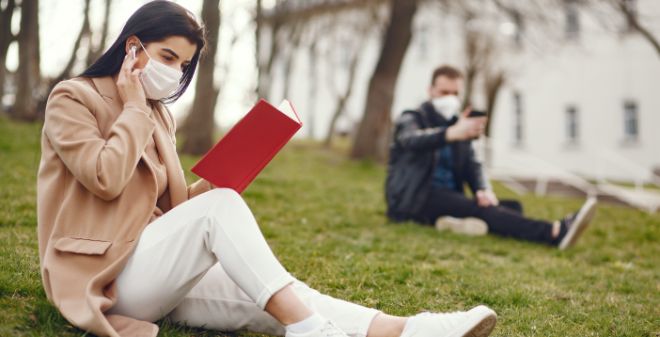 Woman and man reading with face masks. 