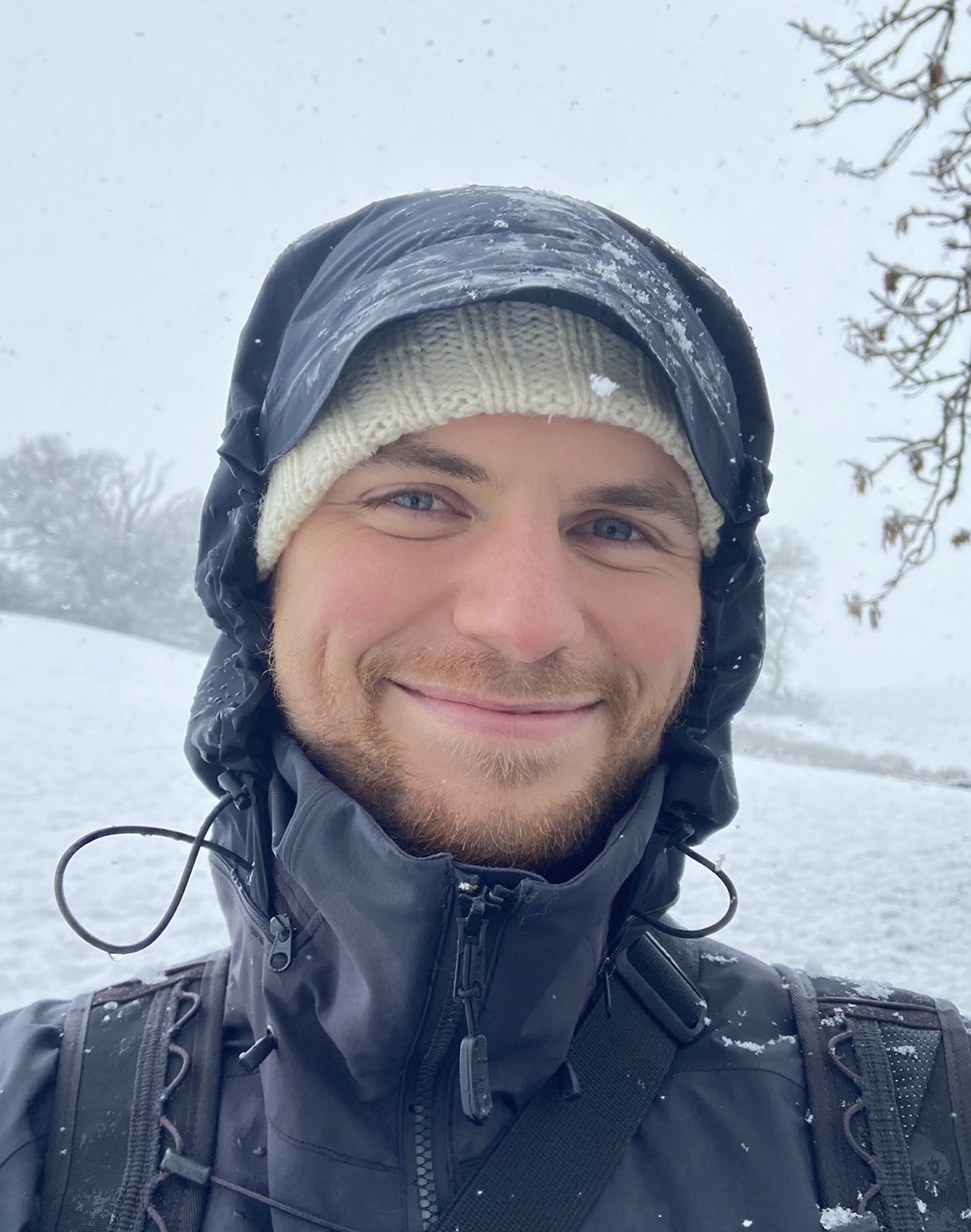 Portrait photo of a smiling Oscar Davies in snowy weather. 
