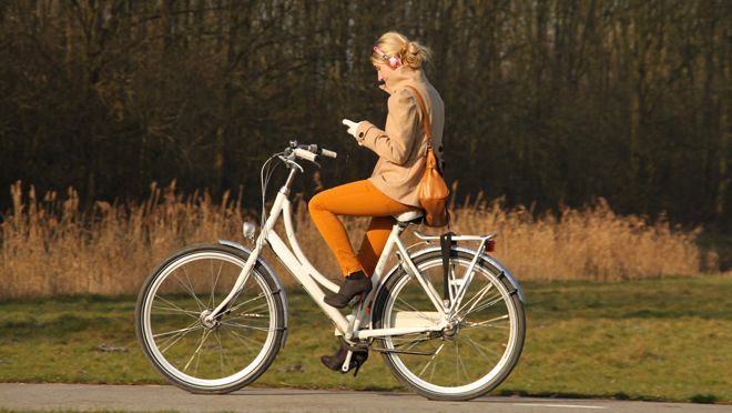 distracted girl on bike using smartphone