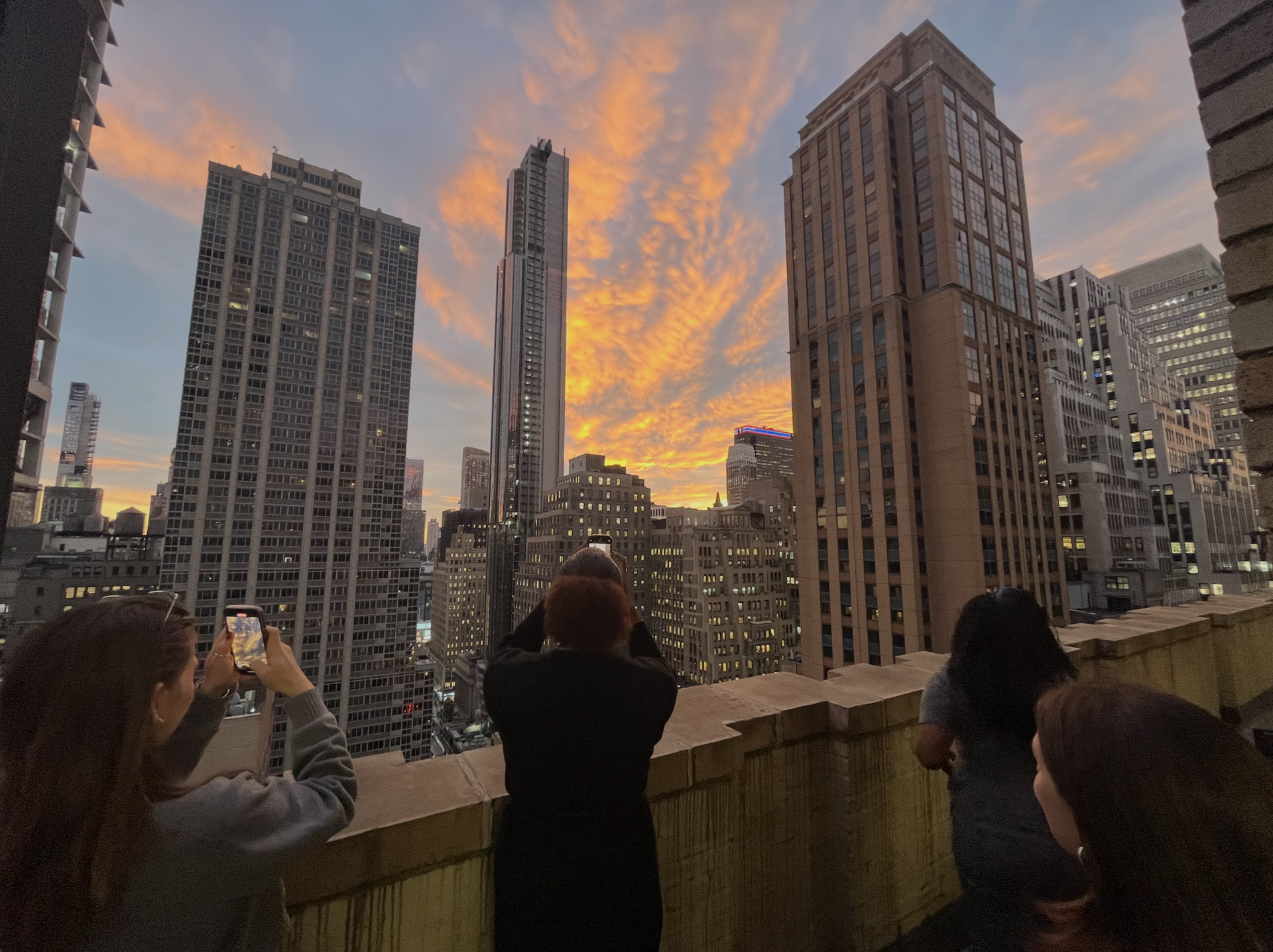 roof terrace, people taking pictures of sunset, downtown new york, skyscrapers