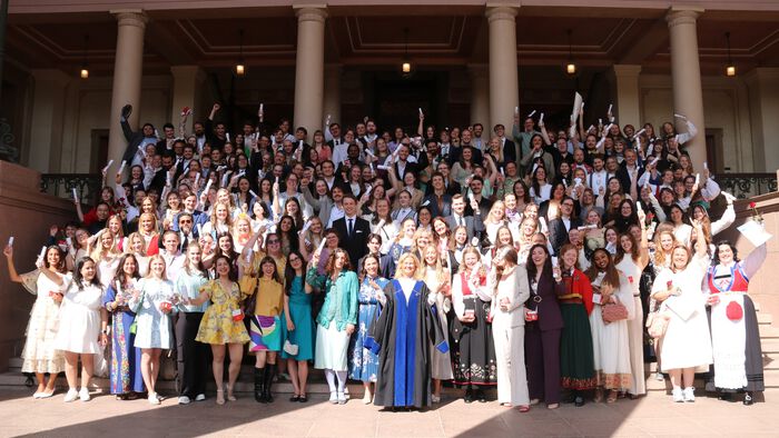 Hundreds of beautifully dressed, cheering people on a stone staircase