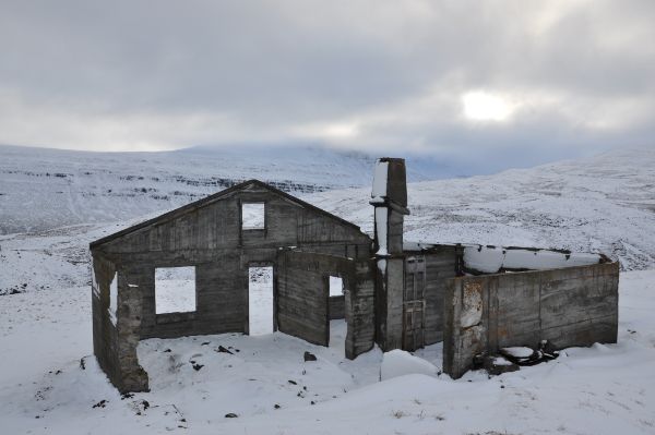 Rester av en murbygning i et vinterlandskap. Foto. 
