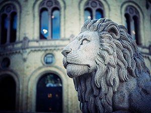 Statue of a lion in front of the Storting.