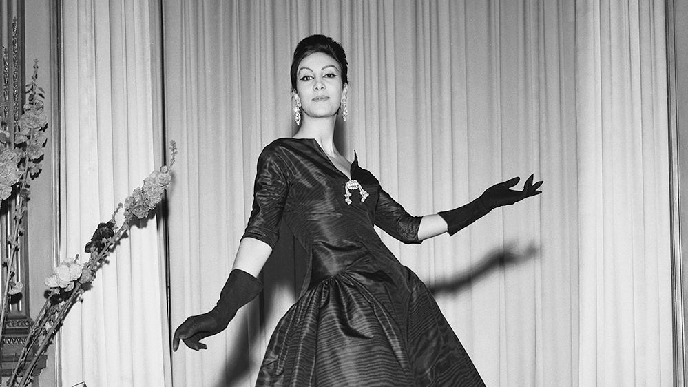 Black and white photo of woman in elegant dress.