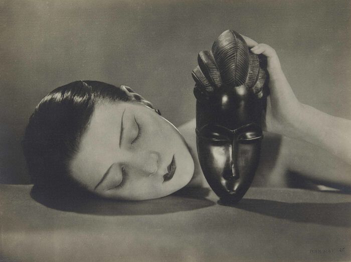 A woman holding an African mask. Black and white photo.