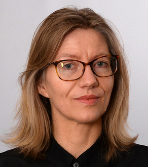 A portrait of a blond woman with glasses