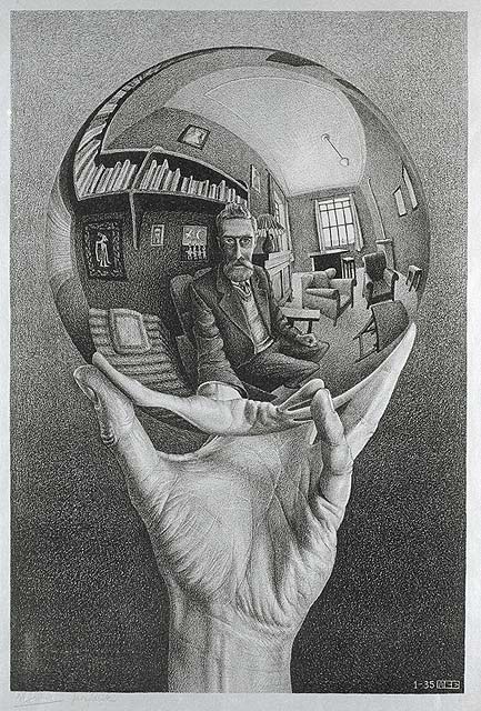 Hand holding a glass sphere that reflects the mirror image of the man holding it.