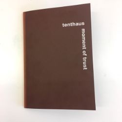 En brun bok med påskriften​" Tenthaus. Moment of Trust".