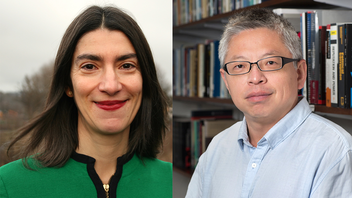 A woman in a green shirt with black hair on the left; a man in a blue shirt with glasses on the right.