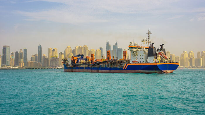 A cargo boat approaching a harbour in the Gulf.