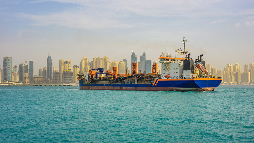 A cargo boat approaching a harbour in the Gulf.