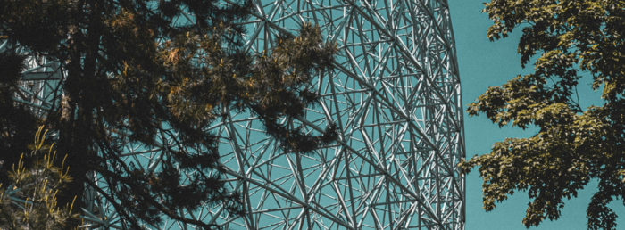 Trees, blue sky and a metallic sculpture. Photo.