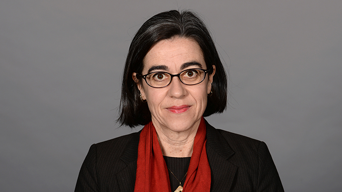 En middelaldrende kvinne med mørkt hår og briller. Foto