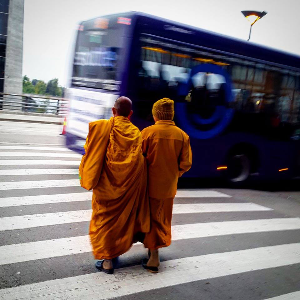 To munker kledd i oransje går over et fotgjengerfelt 