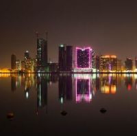 Silhuetten av Bahrain mot himmelen, reflektert i havet