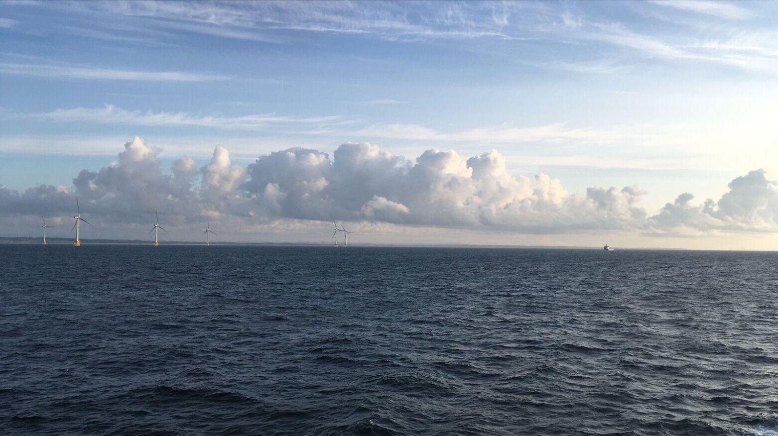 sky and ocean with wind turbines