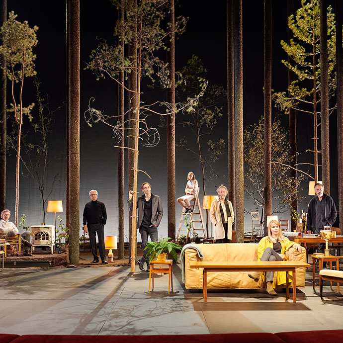 Scenen på Nationaltheatret med skuespillere som står og sitter i en skog