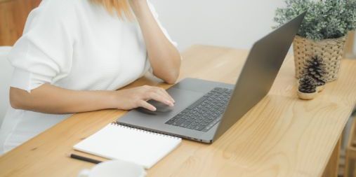 Kvinne ved et skrivebord som bruker en datamaskin. Illustrasjon.