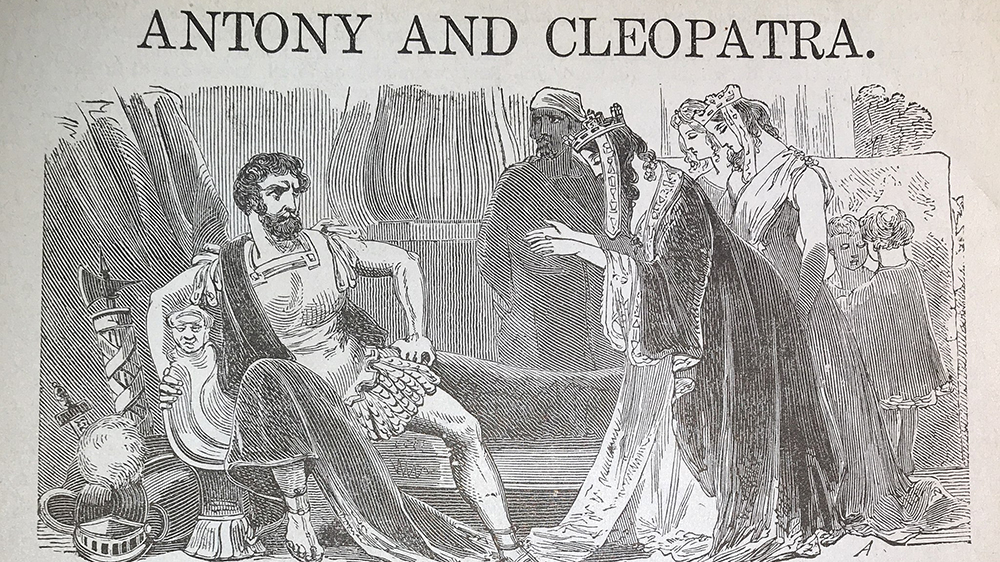 A man and a woman in front. Several others in the background. The image has a text: Antony anc Cleopatra. Illustration. 