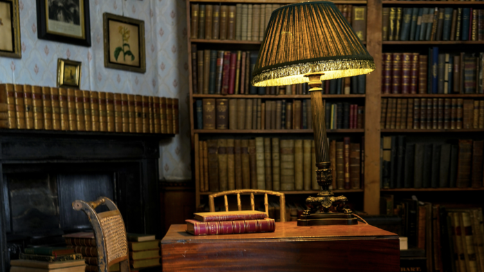 old library desk with books and a lamp. 