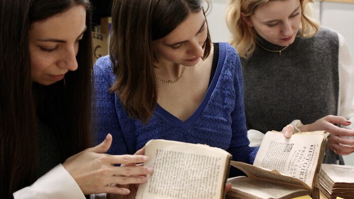 photo to the three doctoral students at the old books collection