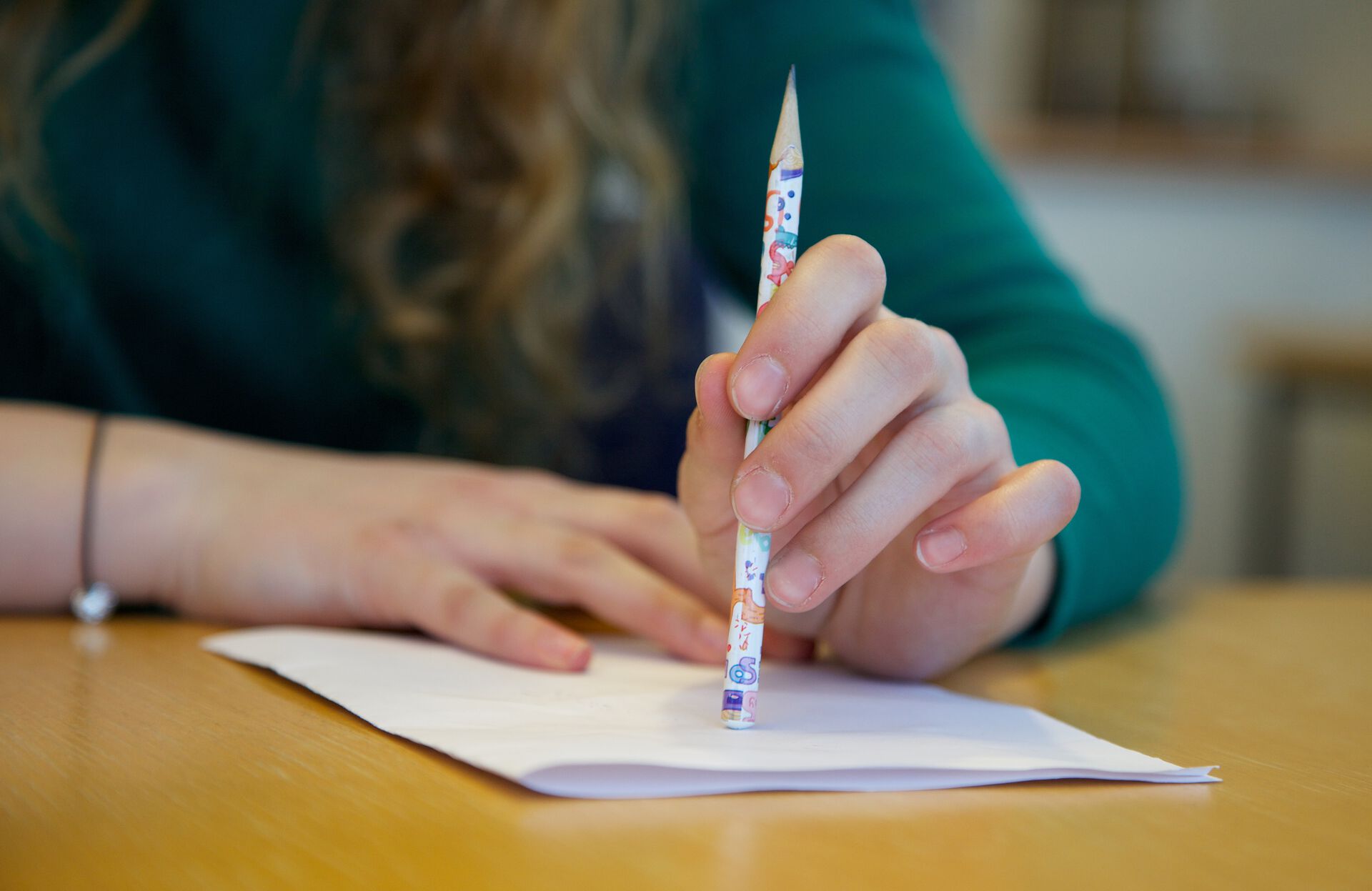 Picture of hands with a pencil, ready to write a text on a sheet of paper. Photo.