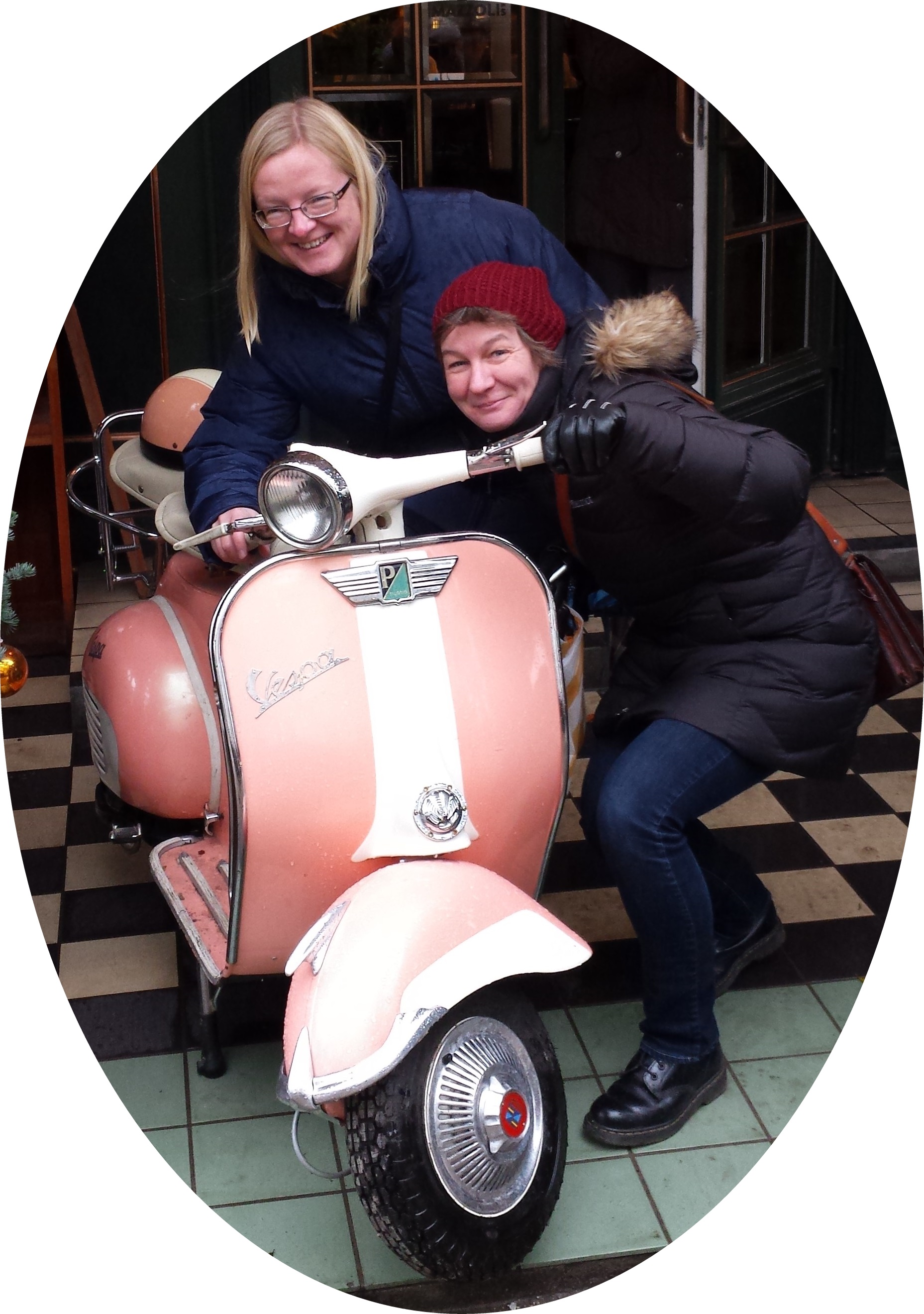 Two women next to a Vespa Scooter