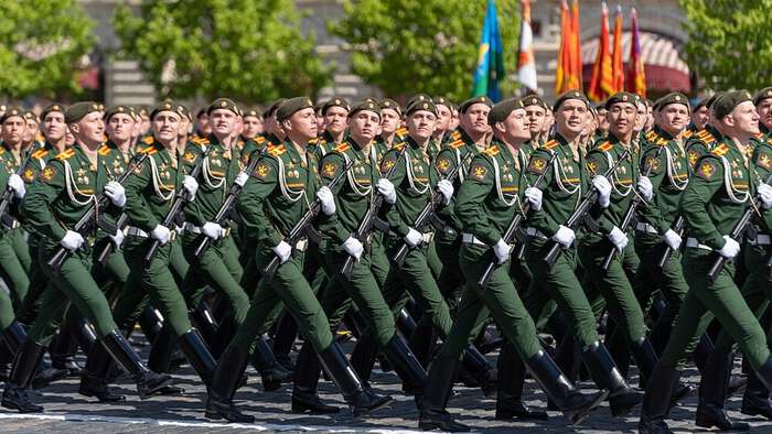 Russian troops marching with guns in a parade. Photo