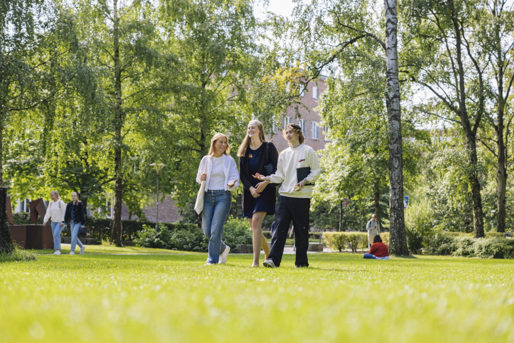 Studenter i grønne omgivelser på campus