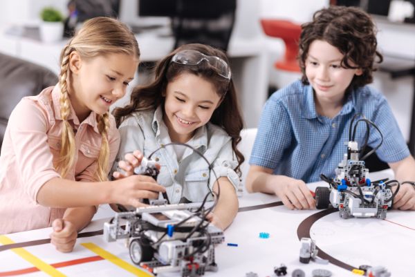 Image contains children working with robots