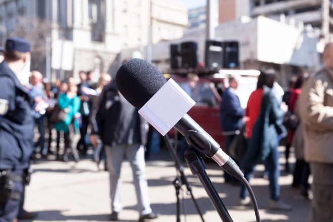 A microphone and crowd protesting on the street