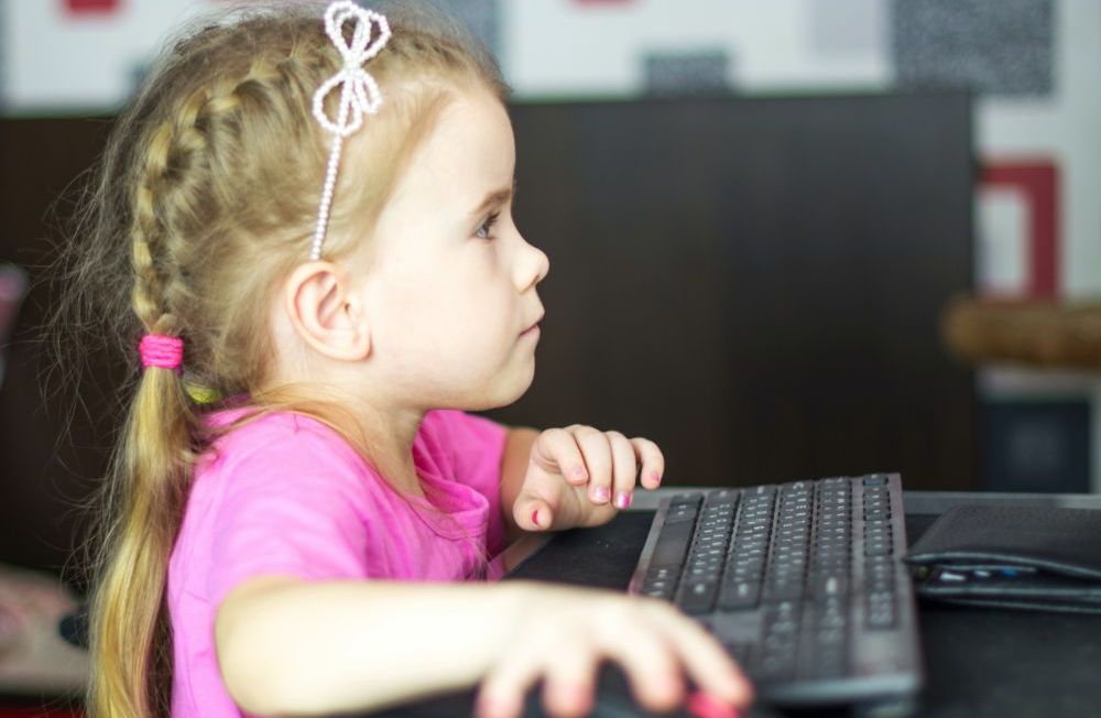 Young girl using a desktop computer.