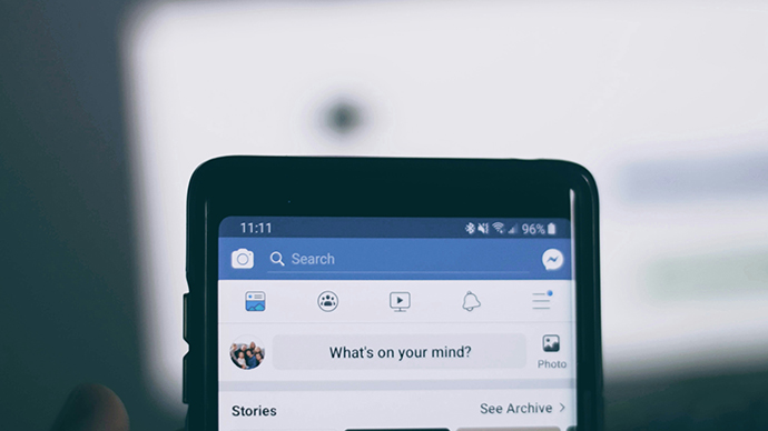 Mobile phone screen with Facebook app. Photo. 