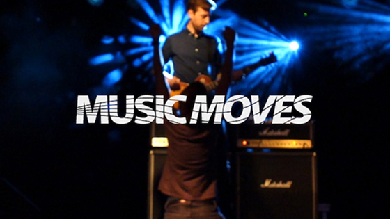 Mann som spiller gitar på en scene med teksten "Music moves" over. Foto. 