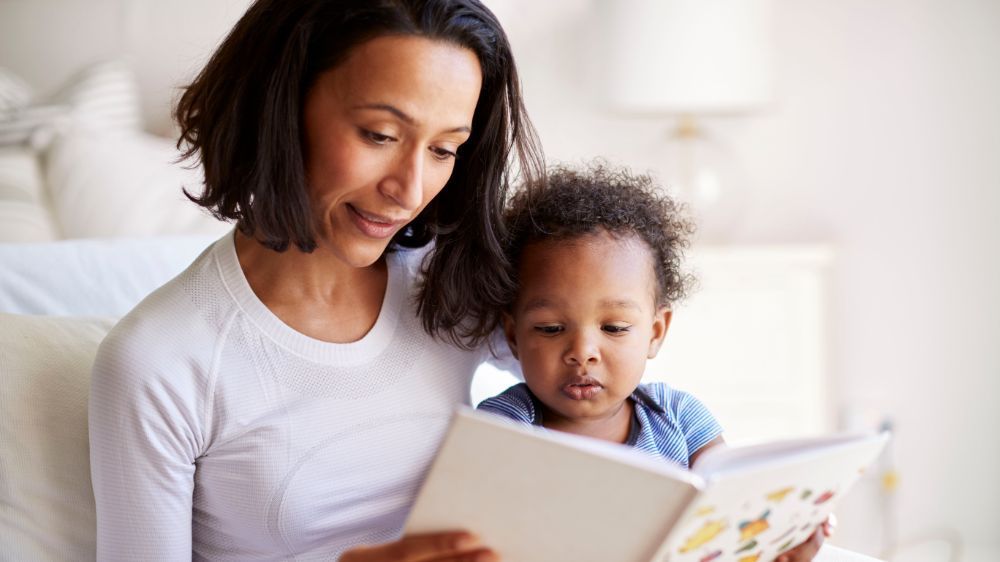 Photo of woman reading to small child