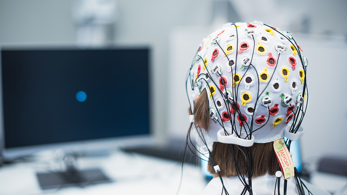 Kvinne som har på seg en EEG hette. Foto.