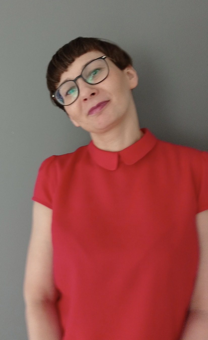 Profile picture of Madgalena. She is wearing a red blouse. She has short hair and glasses.