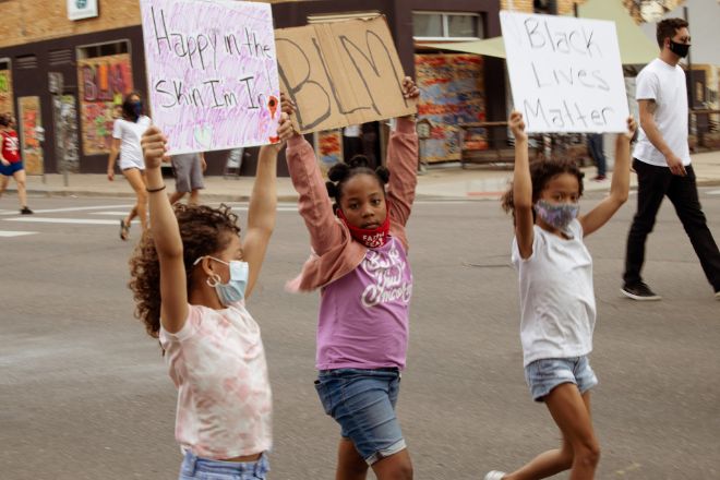 Three young girls marching in a Black Lives Matter demonstration in Denver, CO