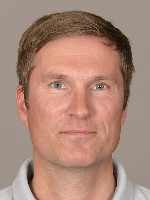 Nærbilde, mann med kort lyst hår, smiler. Fotografi.