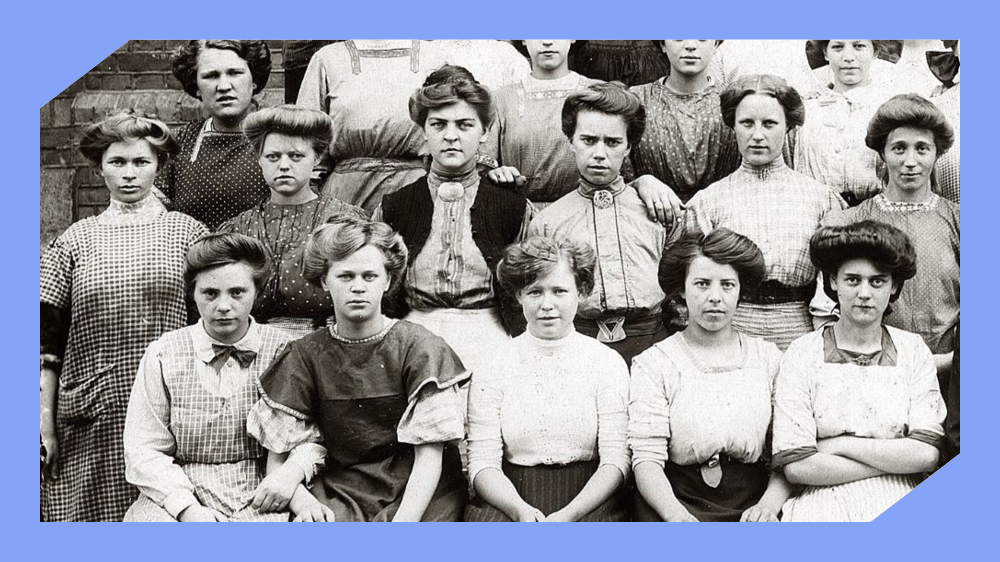 17 arbeiderklassekvinner sitter på rekke og rad og ser rett inn i kamera. Foto i sort hvitt.