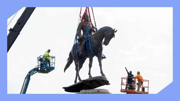En statue av en mann som sitter på en hest, som blir fjernet med kran. Foto.