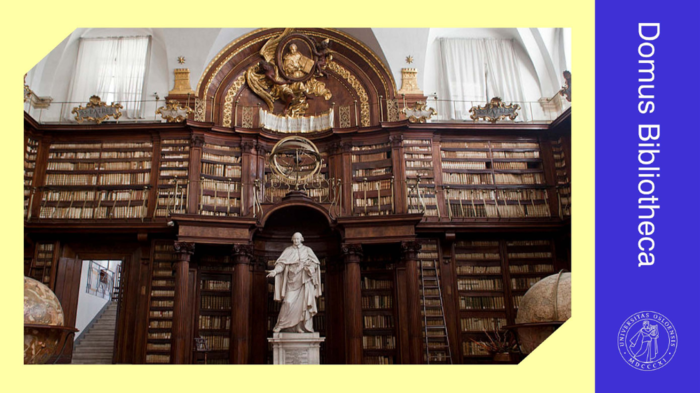 Et bibliotek med store hyller med bøker, i midten står en statue av en mann. Foto.
