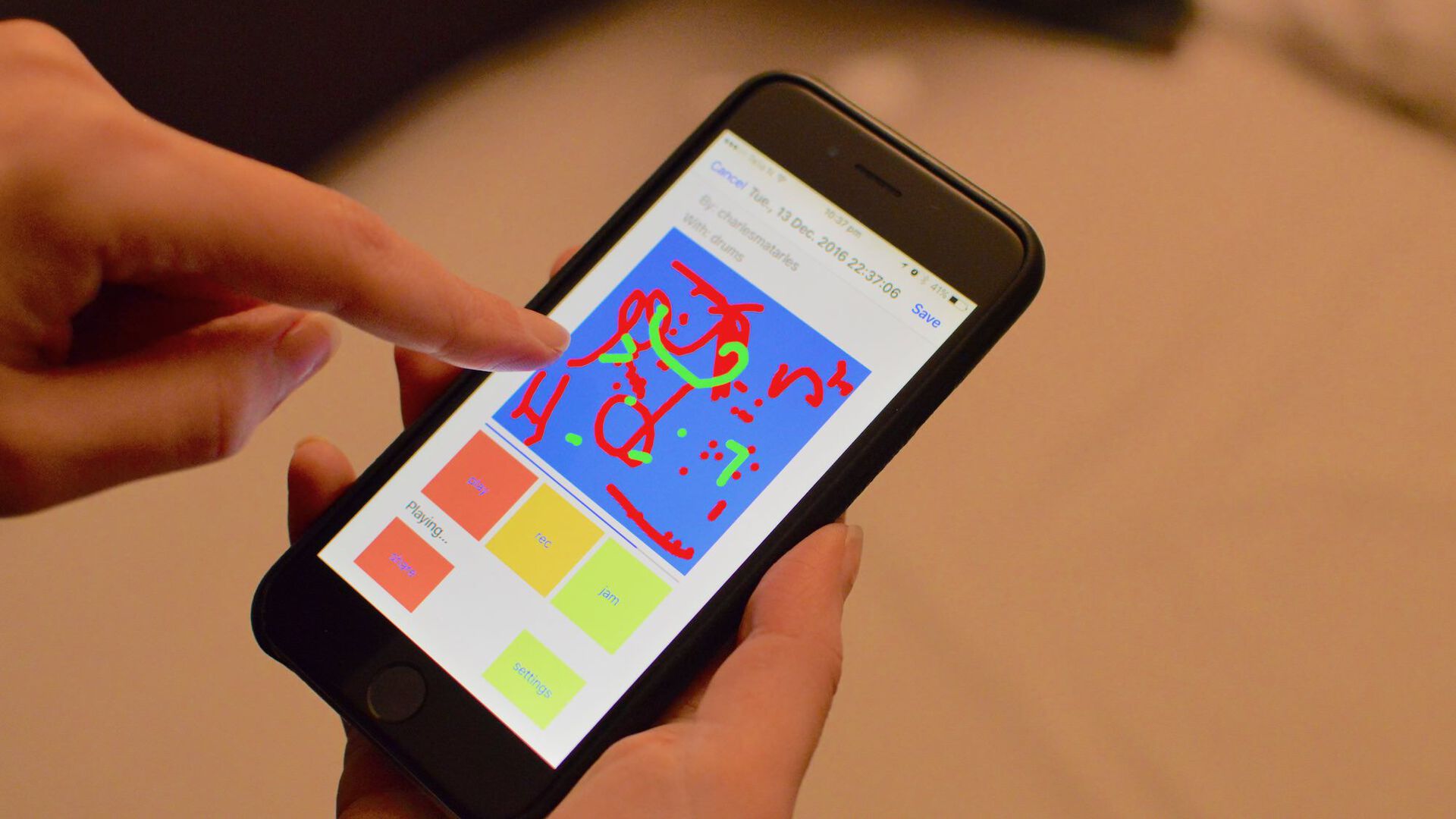 A finger pointing to the screen of a smartphone. On the screen you can see a colorful illustration. Photo. 